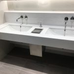 commercial bathroom with two sinks and hanex solid surface countertop